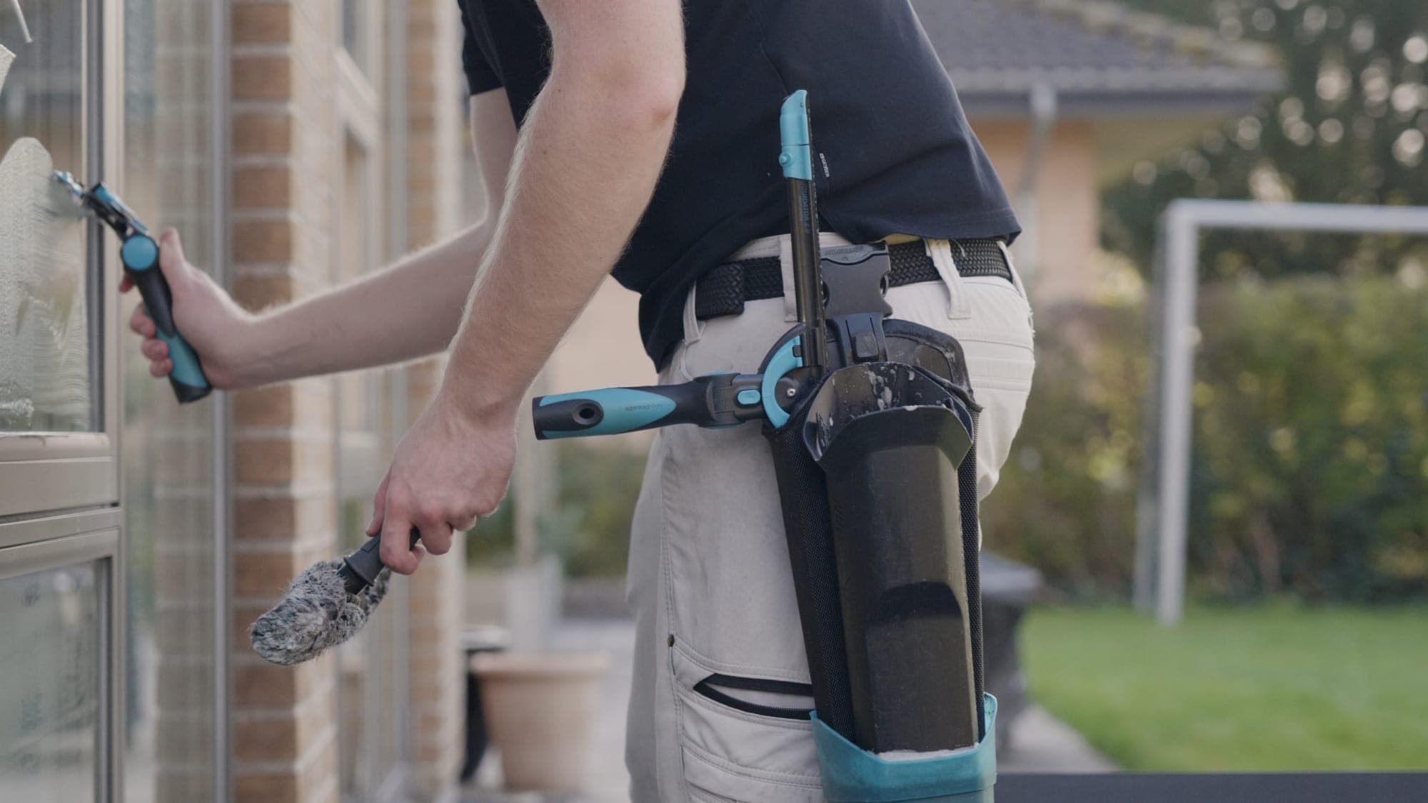 Sparegodt medarbejder med professionelt vinduespudsningsudstyr